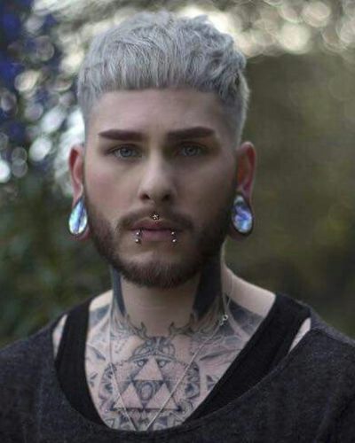 Cheveux blancs coupés avec une barbe courte et des piercings