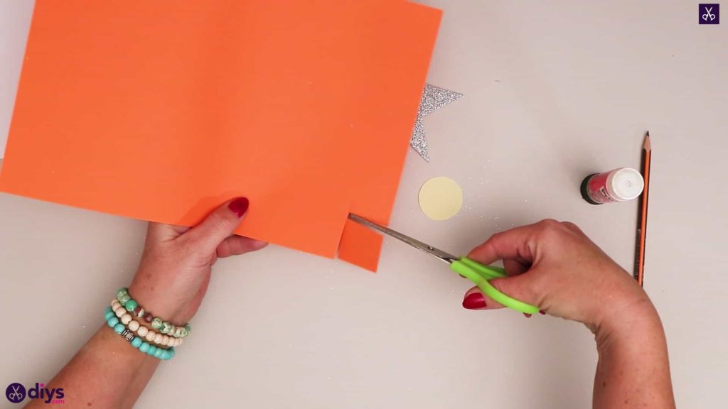 Bougie en papier sur un papier orange étoile